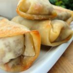 Baked eggrolls on a white plate.