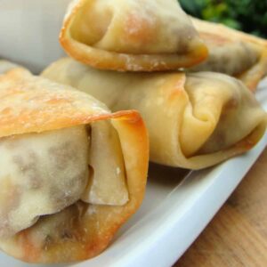 Baked eggrolls on a white plate.