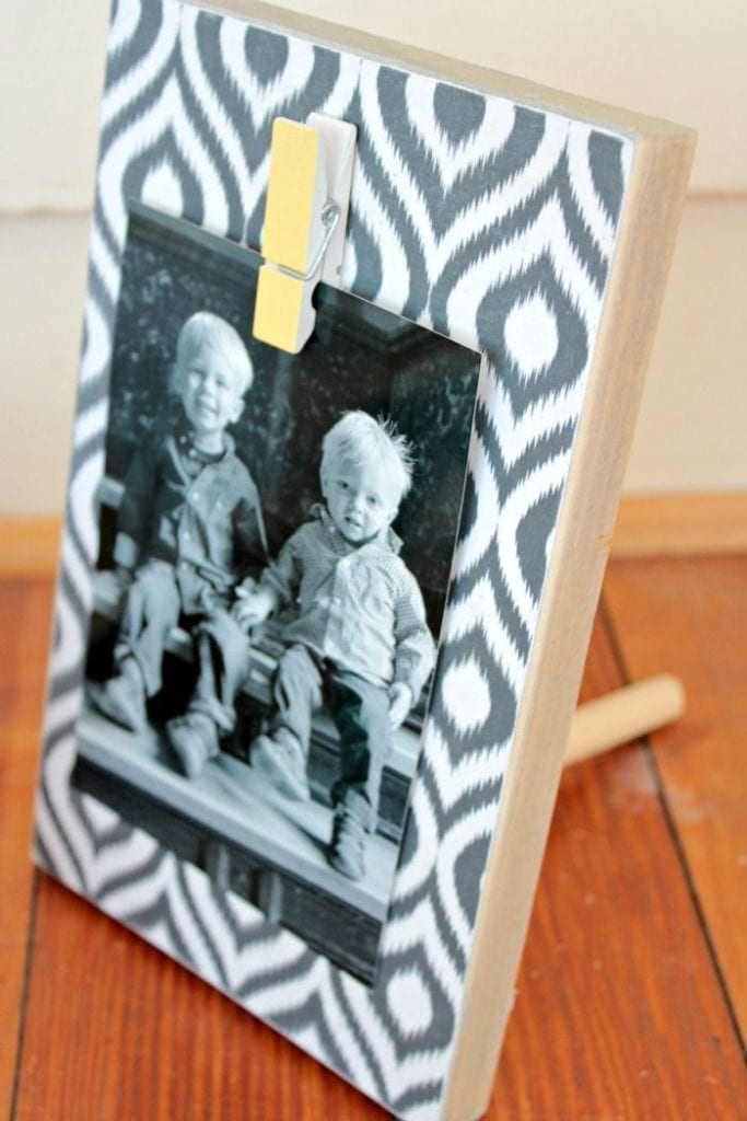 Close up image of a piece of scrap wood made into a photo holder.
