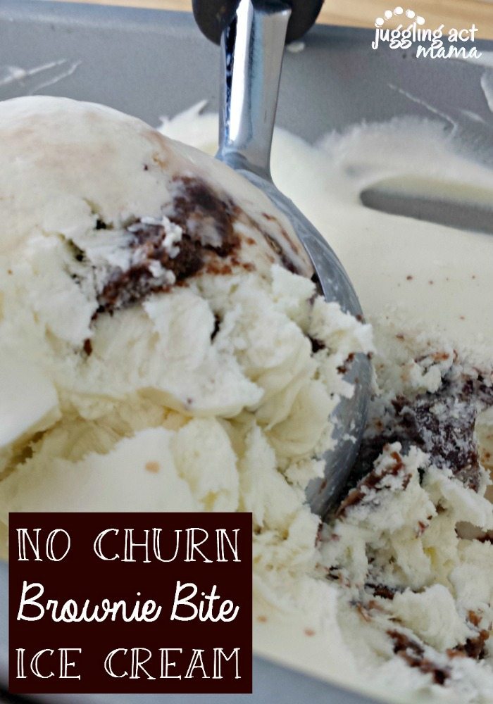 A close up of an ice cream scoop, scooping up No Churn Vanilla Ice Cream with pieces of brownies.