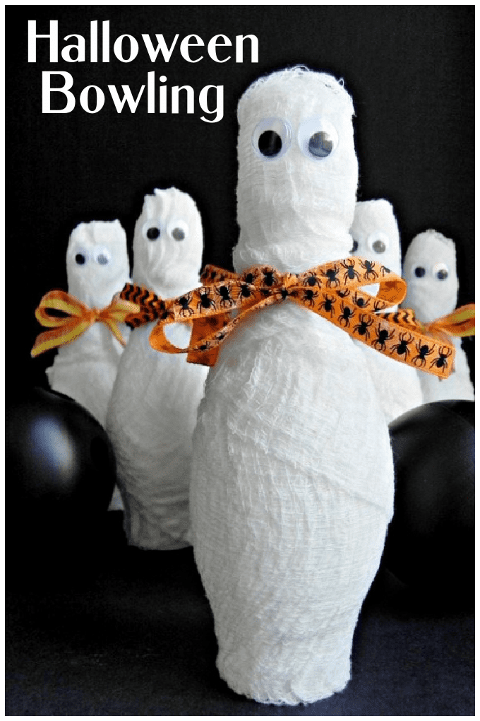 Close up image of a group of mummy bowling pins and small plastic bowling balls.
