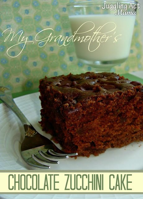 Close up image of chocolate zucchini cake on a white plate with a fork. A glass of milk stands behind.