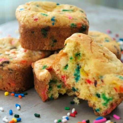 Birthday cake blondies stacked on a plate.