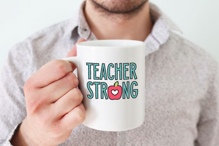 Man holding a teacher strong mug.