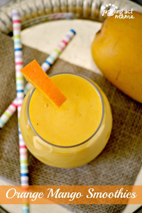 Top down view of an orange smoothie with mango in a clear glass.