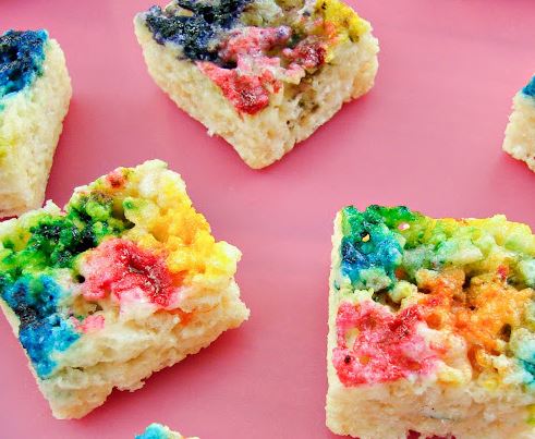 Tie dye rice crispy treats on a pink tray.