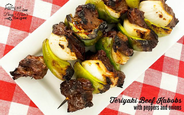 Teriyaki Beef Skewers on white plate on checkered tablecloth.