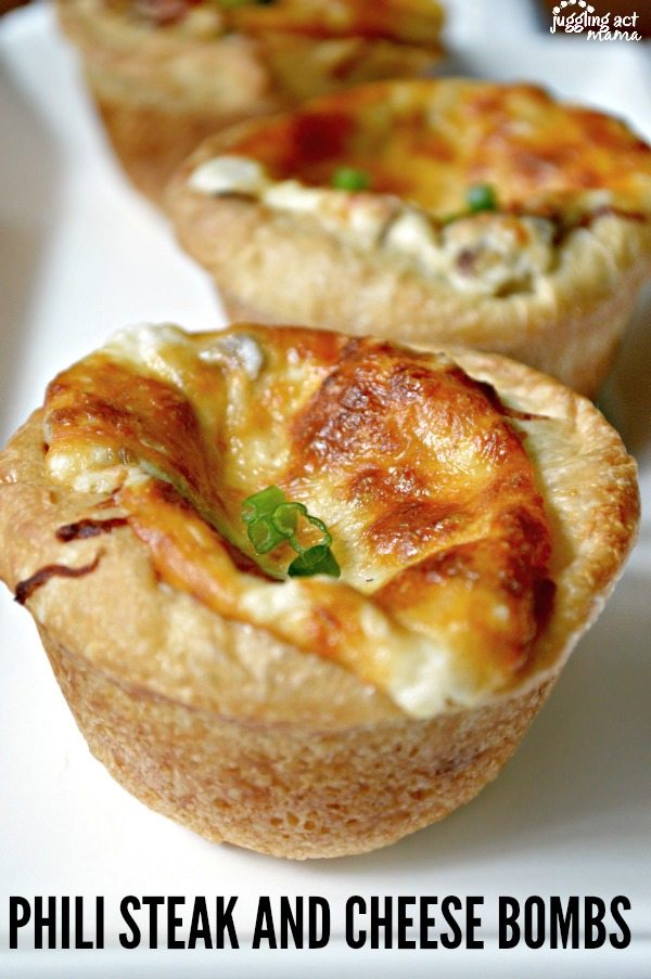 Close up image of the top of a steak and cheese bomb showing baked cheese and green onions.