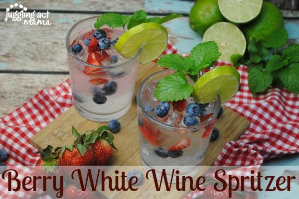 Two glasses of Berry White Wine Spritzer garnished with fresh fruit and mint.