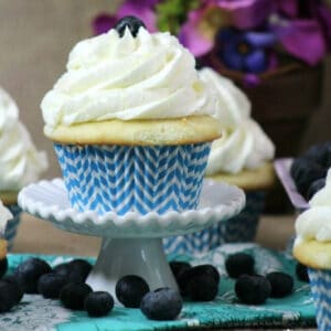 Close up image of a blueberry filled cupcake on a small cake stand.
