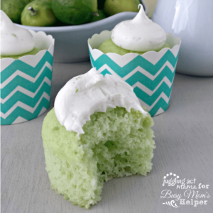 Key lime cupcake with a bite taken out of it next to other cupcakes.