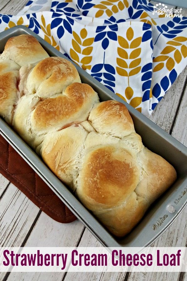 Pull Apart Strawberry Cream Cheese Bread in a 9x5 loaf pan on top of a wooden table with a blue and gold hand towel.