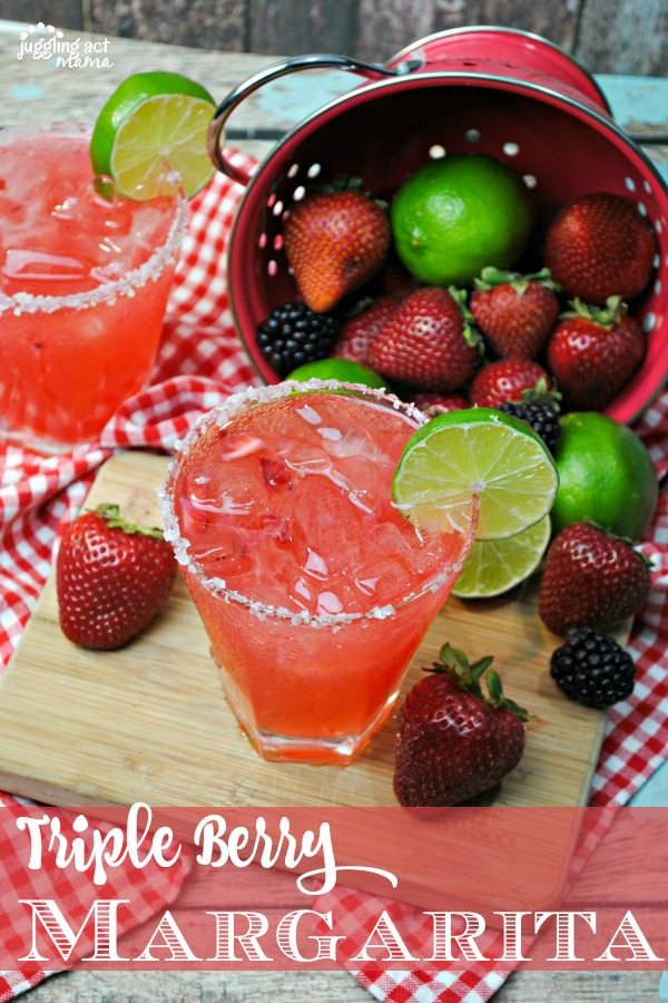 Top down view of a triple berry margarita recipe surrounded by fresh berries spilling from a colander.