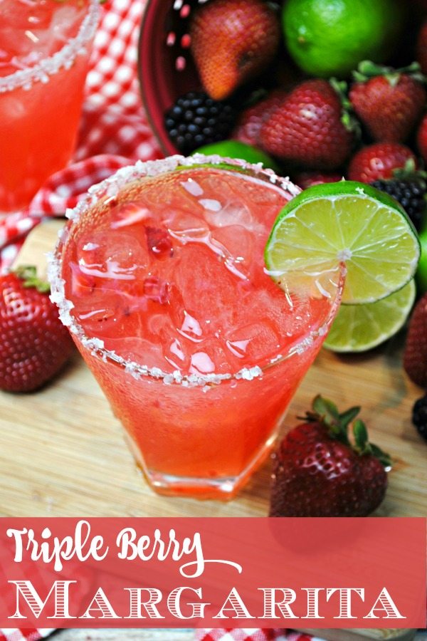 Top down, close up image of a triple berry margarita. The glass has a salt rim and a slice of lime.
