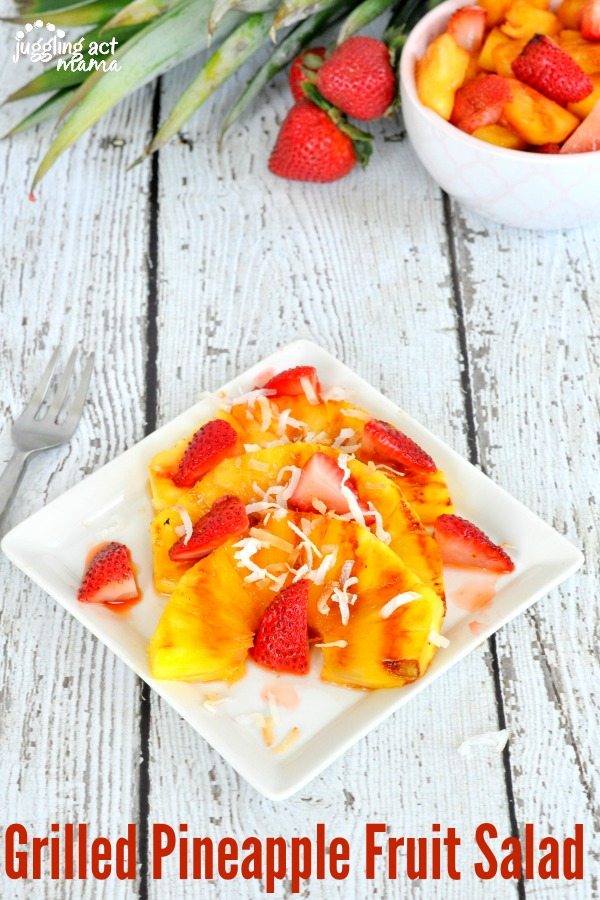 Grilled Pineapple Fruit Salad with strawberries and coconut on a square plate.