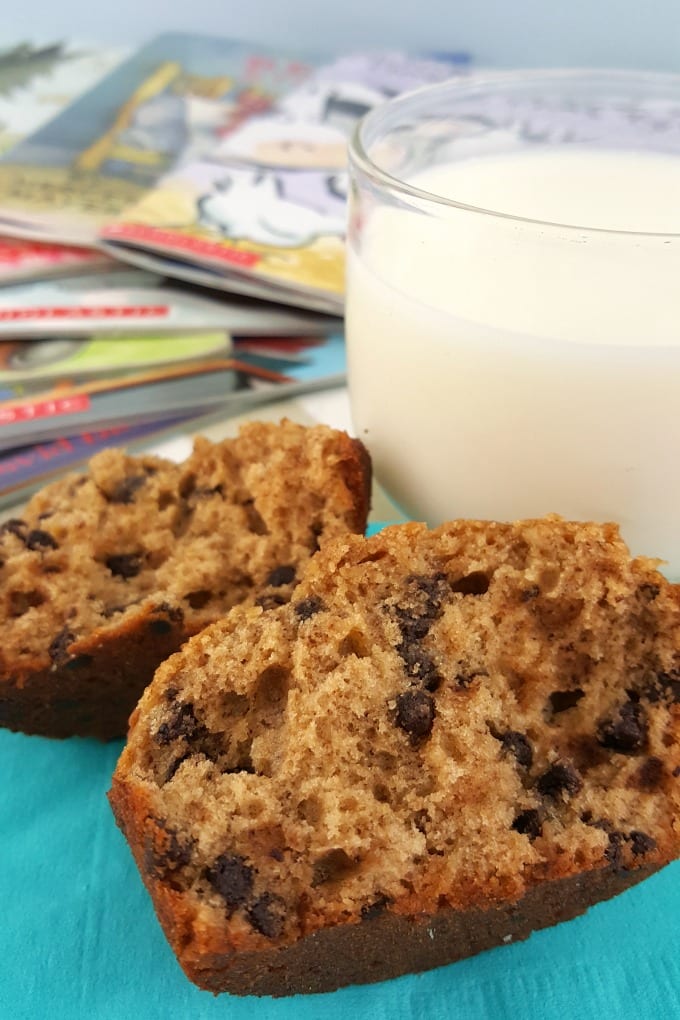 close up of Peanut Butter Chocolate Chip Muffins cut in half next to a glass of milk