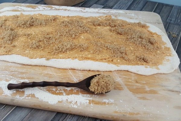 Adding cinnamon and sugar on top of the dough.