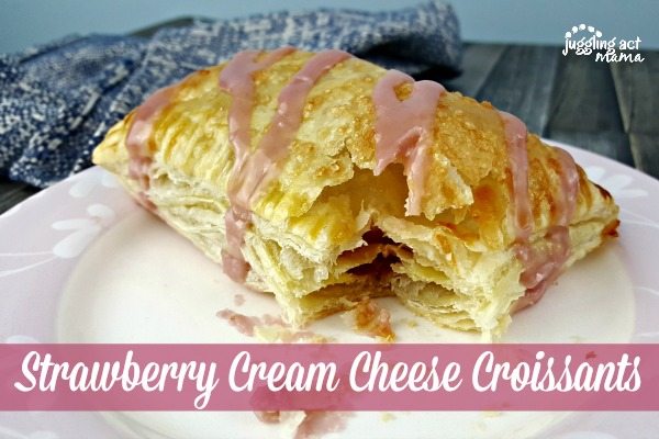 close up of Strawberry Cream Cheese Puff Pastry on a white and pink plate with a blue kitchen towel in the background.