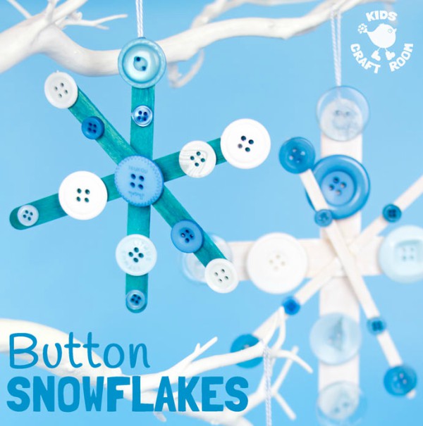Close up image of craft stick snowflakes covered in buttons, and hanging from a white branch.