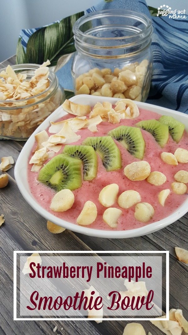 Tropical Strawberry Pineapple Smoothie Bowl with macademia nuts, toasted coconut and fresh kiwi slices.