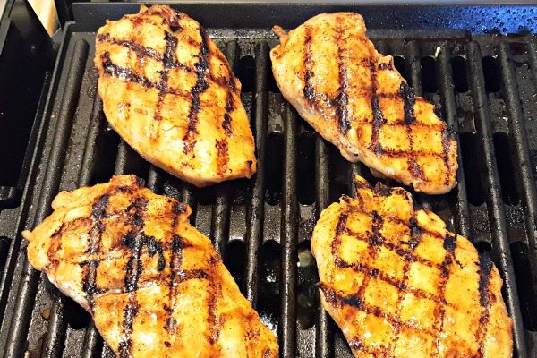 Chicken breasts cooking on the grill.