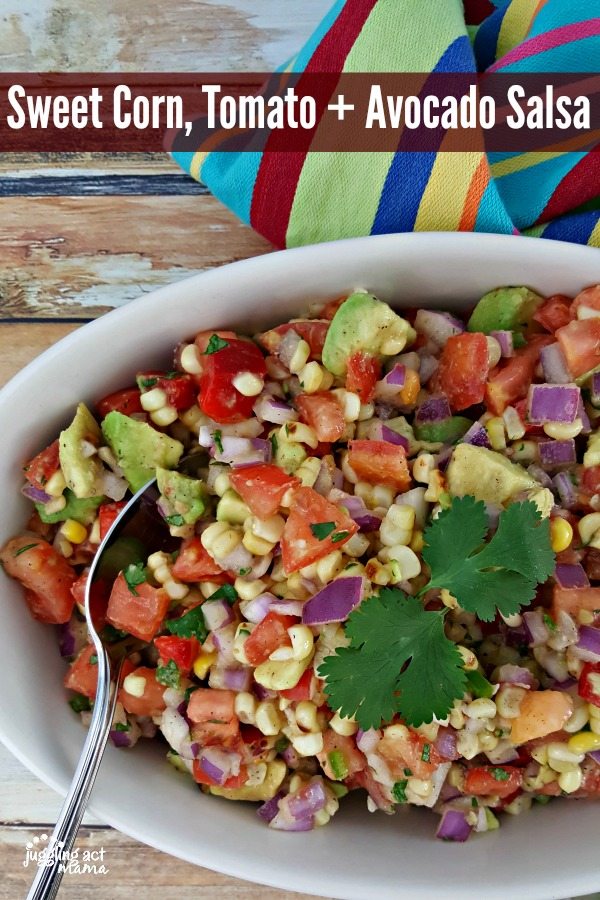 Close up of Sweet Corn, Tomato and Avocado Salsa in a serving bowl with a spoon.