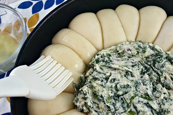 Brushing butter on the rolls. 