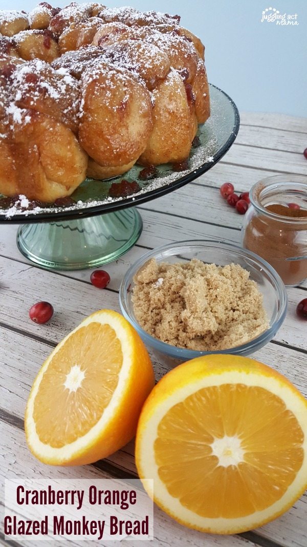Christmas Monkey Bread topped with powdered sugar on a green cake plate and surrounded by ingredients.