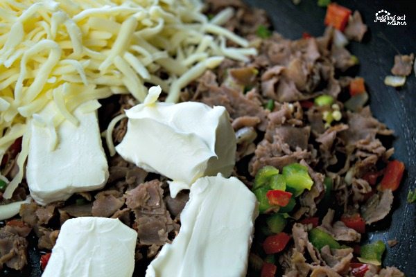 close up of Philly Cheesesteak Dip ingredients in a skillet