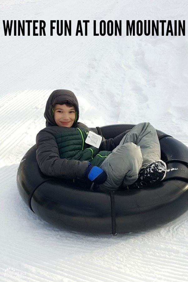 Smiling boy in a snow tube.