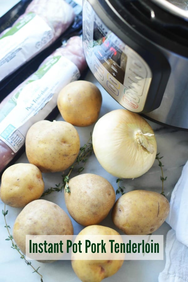 Potatoes and a sweet onion next to instant pot and packages of pork tenderloin