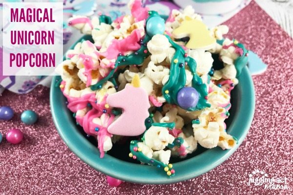 Magical Unicorn Popcorn covered with sprinkles and melted chocolate in blue dish.