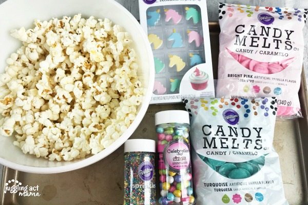 Popped popcorn, sprinkles and melting chocolate - supplies needed to make unicorn popcorn.