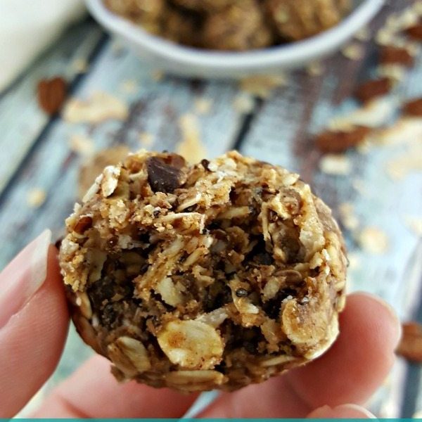 Close up image of a hand holding an oatmeal peanut butter chocolate chip balls.