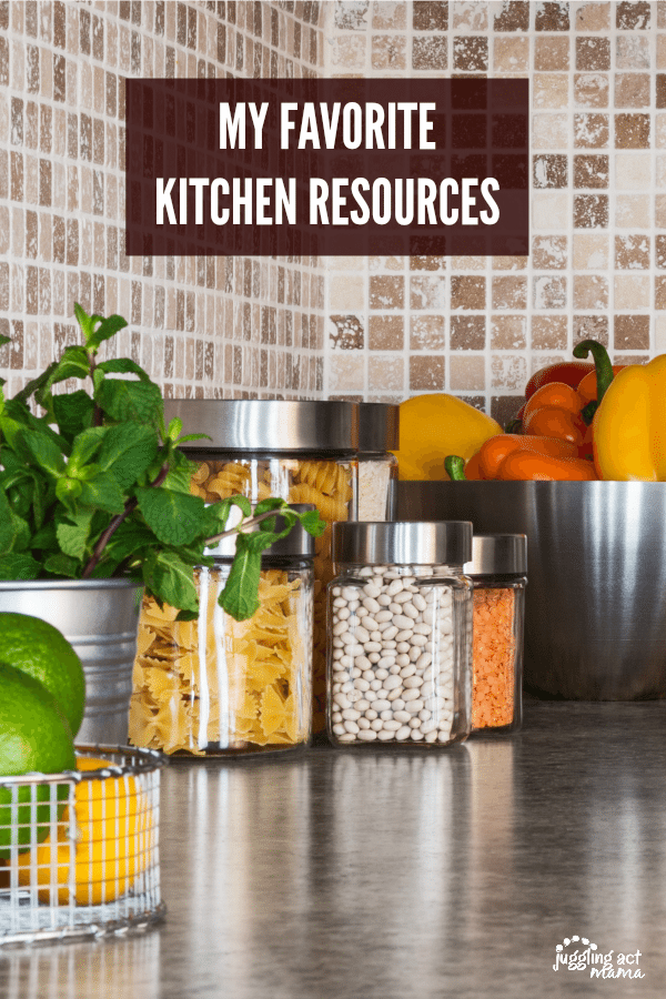 Kitchen Resources Featured Image - A grey countertop with pantry staples like pasta and beans in clear jars with silver lids. A large silver bowl filled with red, orange and yellow peppers. A pot of fresh mint. A baskete of limes and lemons.