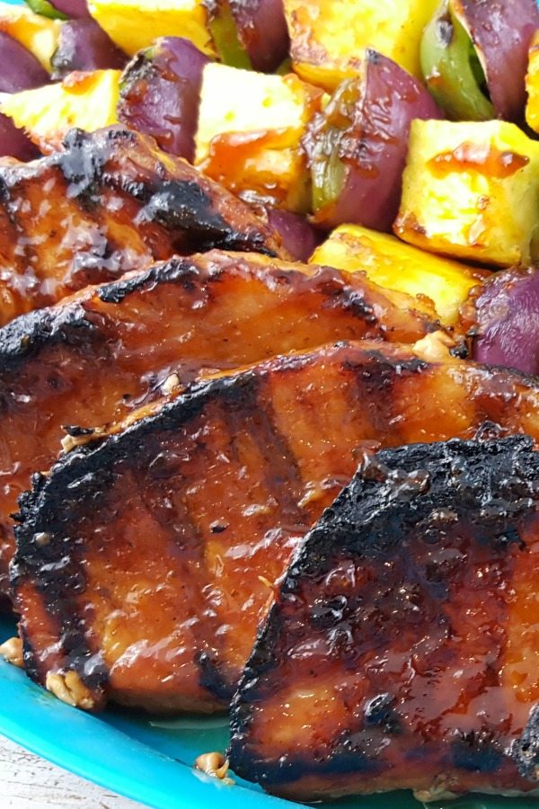 Close up image of grilled pork chops and vegetables.