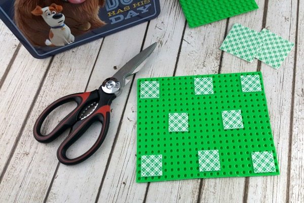 Mounting squares on the back of a LEGO flat next to snips.