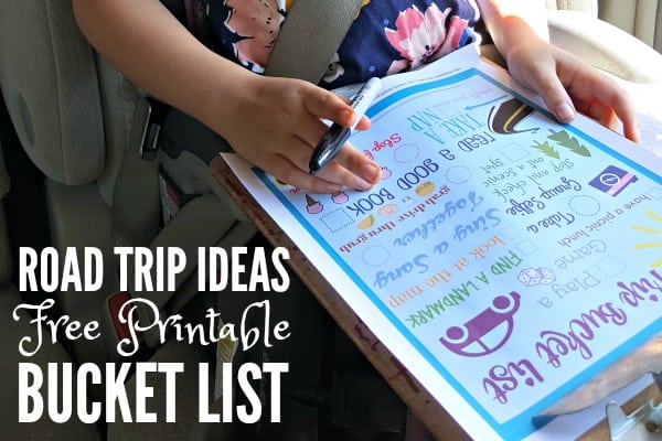 Little girl holds a Road Trip Ideas Free Printable Bucket List and marker.