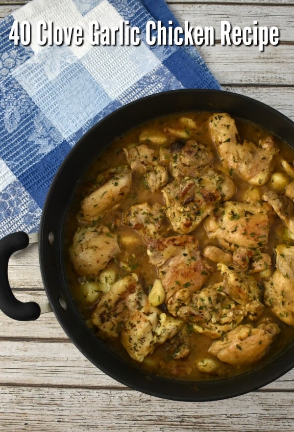 40 Clove Garlic Chicken Recipe in a large skillet on a work surface with blue kitchen towel.