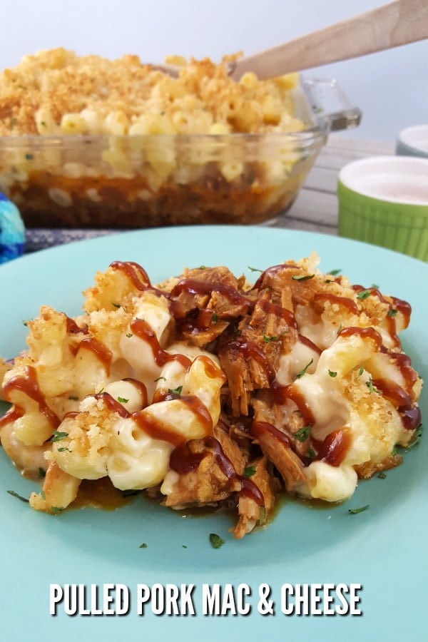 Pulled Pork Mac and Cheese on a light blue plate with a casserole dish in the background