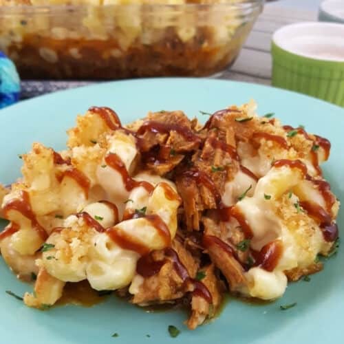 Plate of Pulled Pork Mac and Cheese with a casserole dish in the background.