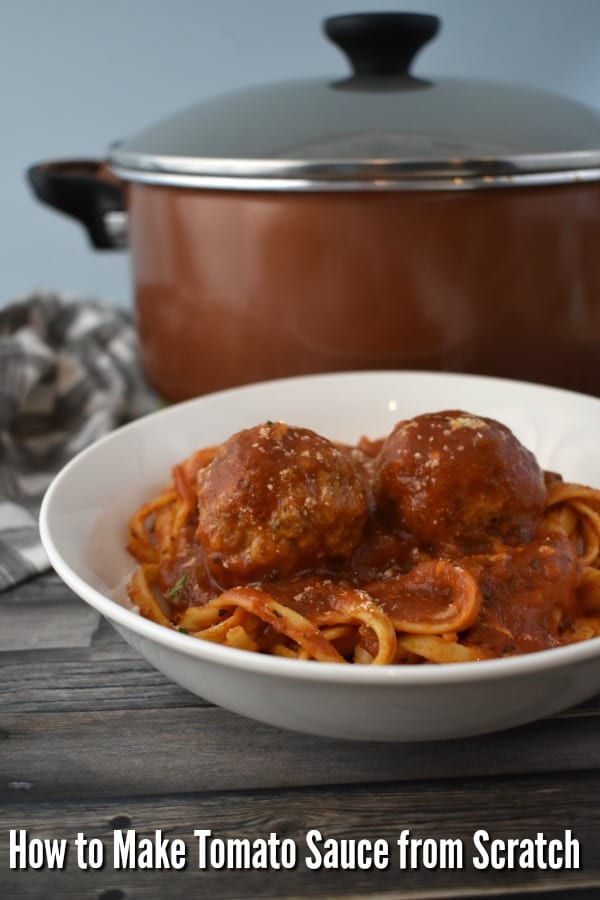 How to Make Tomato Sauce from Scratch - bowl of pasta with meatballs in front of a copper stock pot