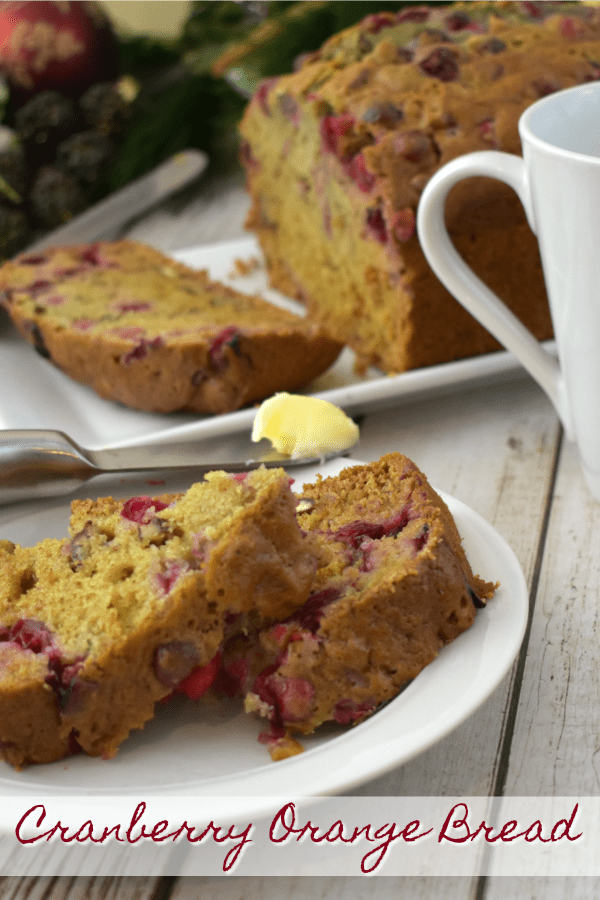 Two slices of Cranberry Orange Bread on a small plate with a butter knife.