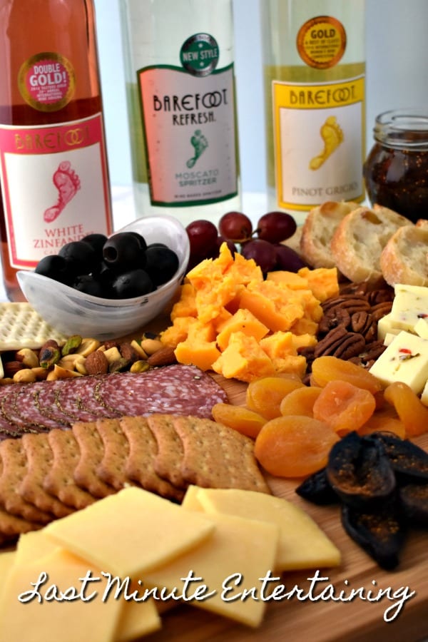 a Meat and Cheese Platter arranged with with fruit and dried fruit, cheeses, olives, salami, nuts and more.