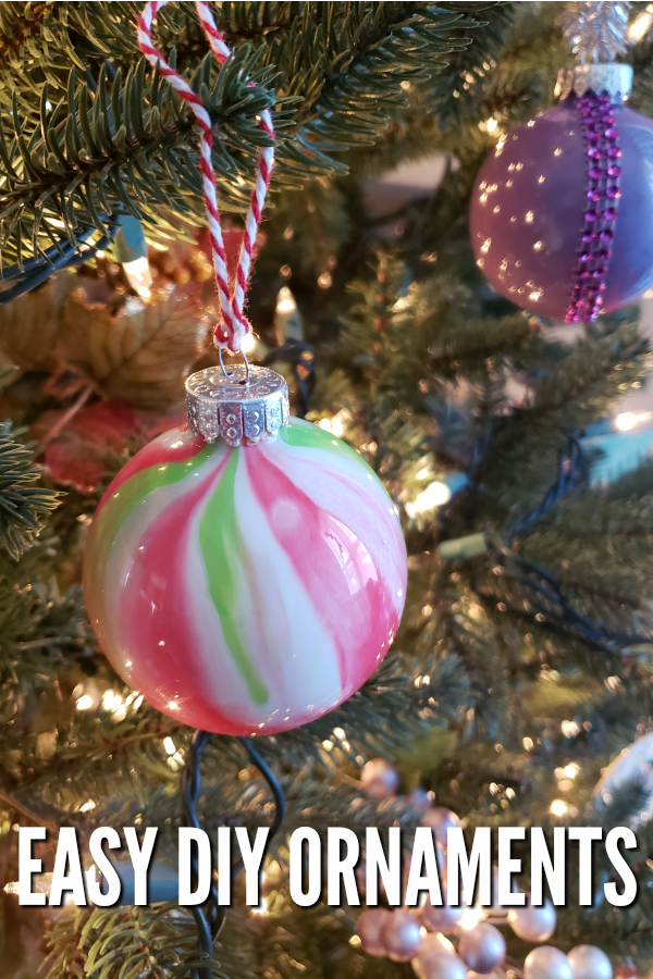Close up image of a marble Christmas ornament hanging by bakers twine on a Christmas tree. 