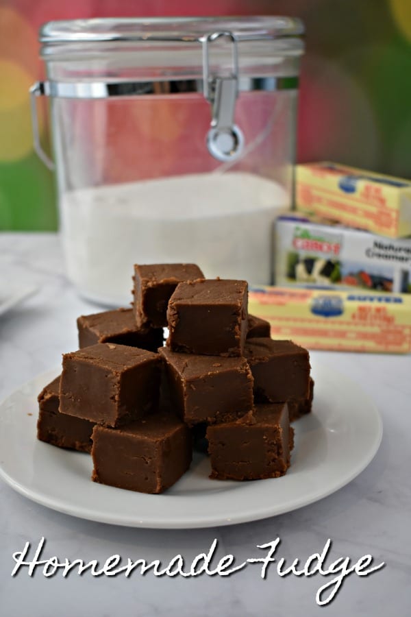 Plate of Old Fashioned Chocolate Peanut Butter Fudge with sugar and butter in the background.