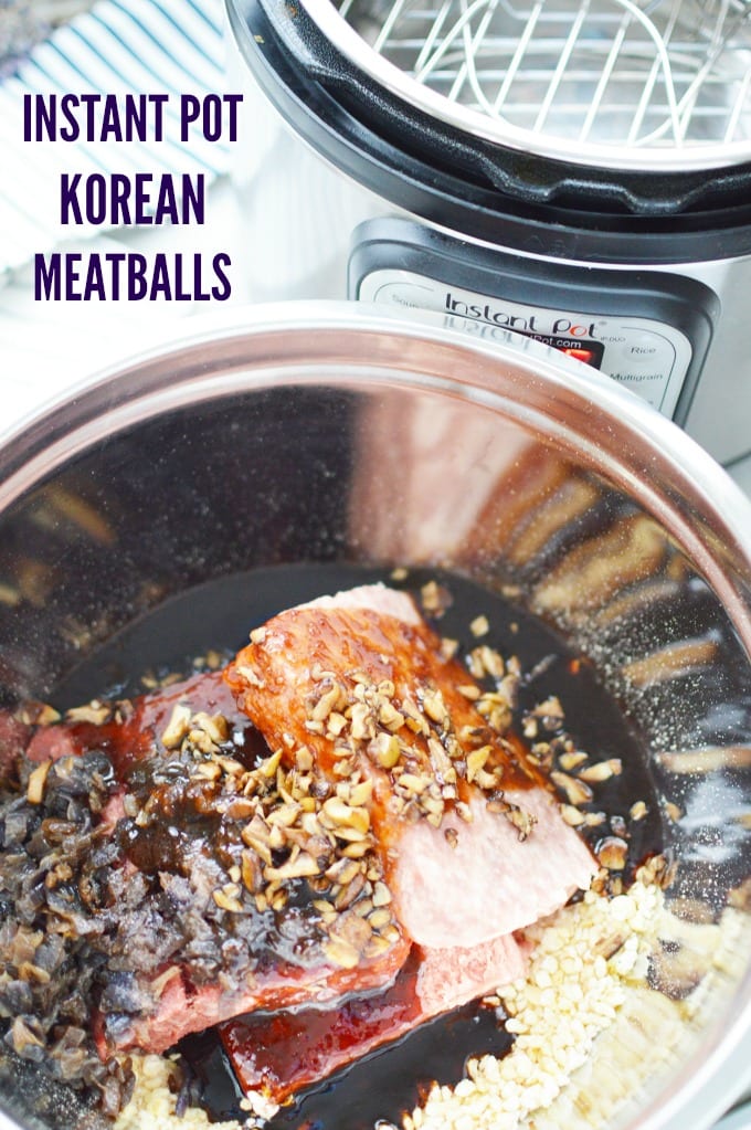 Ground beef and pork in a metal mixing bowl with Korean BBQ sauce, sautéed onions, and breadcrumbs. An Instant Pot can be seen in the background.