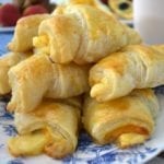 Ham and Cheese Croissants piled on a blue and white plate.