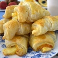 Ham and Cheese Croissants piled on a blue and white plate.