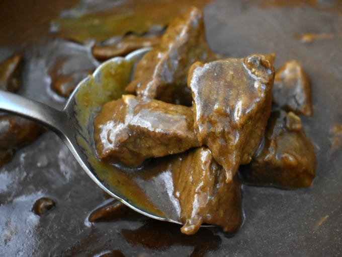 Close up of beef tips and gravy on a serving spoon